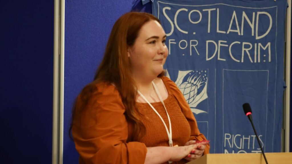 Scotland for Decrim's political officer Laura Baillie talking at Holyrood.